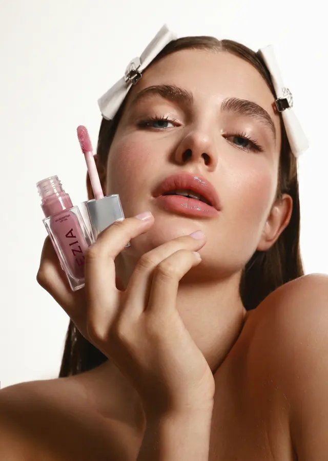 Editorial close-up of glossy lips with a high-shine mauve-pink finish